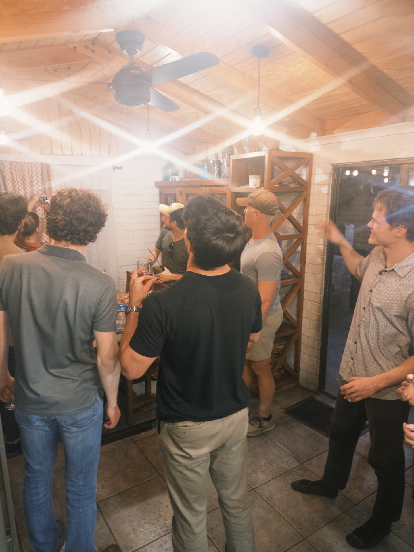 Fellows gathered in the house kitchen under warm lighting