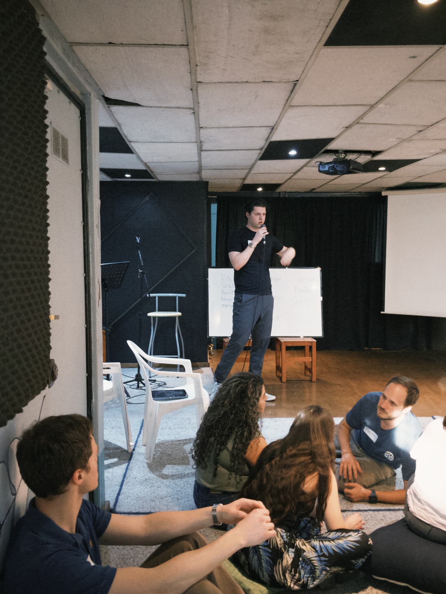 A fellow presenting at a whiteboard during a house mastermind