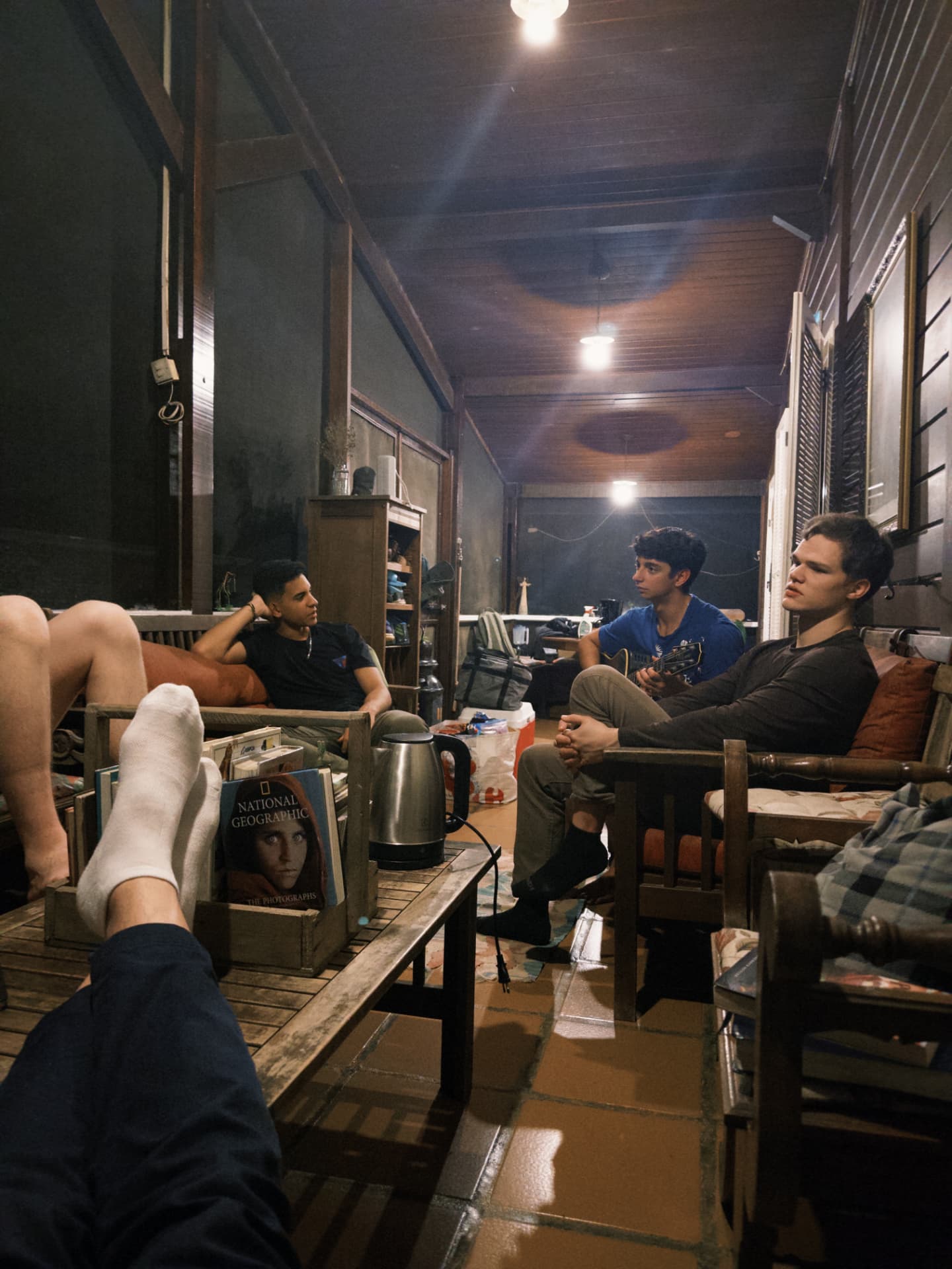 Fellows sitting and talking on the porch at night